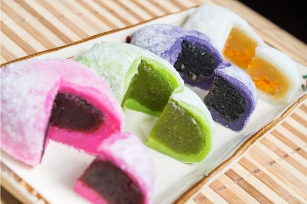 Imagem de um prato com diversos doces japoneses coloridos e bem decorados.